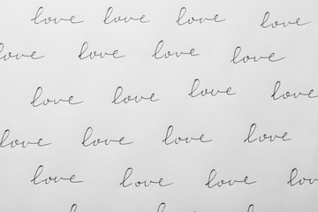 Word LOVE written multiple times on white background, top view