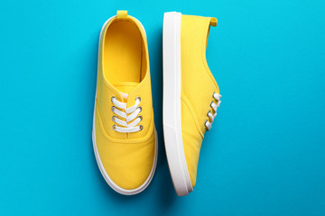 Pair of bright sneakers on colorful background, top view