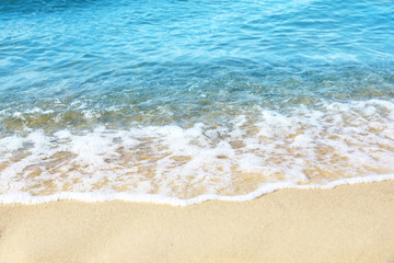 Fototapeta na wymiar View of sea water and beach sand on sunny day