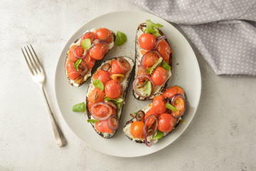 Vegan sandwiches, bruschettas with cheese cream and cherry tomatoes. Whole bread slices.