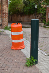 Fototapeta na wymiar Orange construction barell on the cobblestone