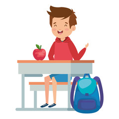 student boy seated in school desk with apple and bag