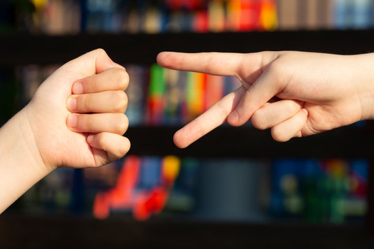 Kids are playing a hand game Rock-paper-scissors on the playground.