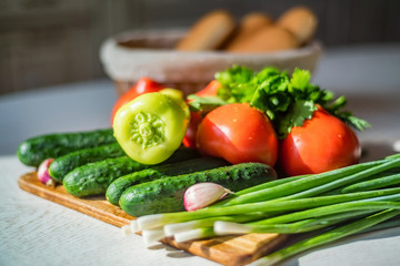 Fresh seasonal vegetables on wooden board on table.