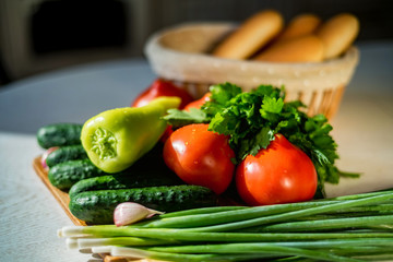 Fresh seasonal vegetables on wooden board on table.