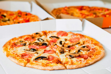 Delicious pizza with tomatoes, mushrooms and cheese in paper box