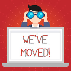 Text sign showing We Ve Moved. Business photo showcasing having strong feelings sadness or sympathy has said or done Man Holding and Looking into Binocular Behind Open Blank Space Laptop Screen