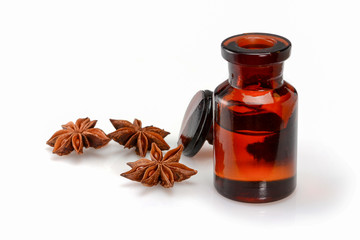 Essential star anise oil in a dark brown glass special bottle with ground glass stopper. Isolated on white background.