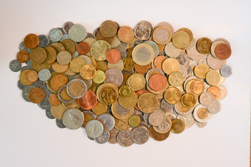 Scattered coins of different countries in the form of a cloud on a white background