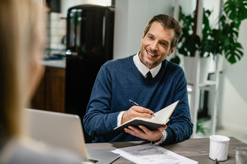 Happy financial advisor planning home budget with his client.