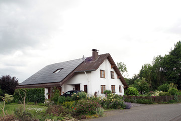 Fototapeta na wymiar Einfamilienhaus im Landhaus-Stil mit Photovoltaik-Anlage
