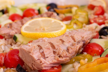 Close-up of rice salad with fresh vegetables and grilled mackerel