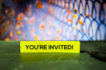 You're Invited! on the sticky notes with bokeh background