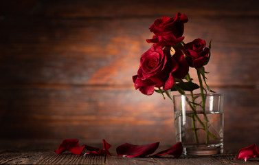Red rose in vase on old wooden background, Vintage style