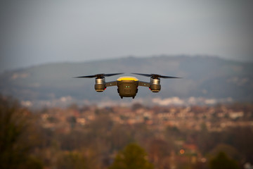 Yellow drone flying over a city