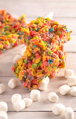 Fruity Cereal Marshmallow Treat Bars on a Wood Table