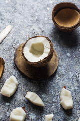 Fresh raw organic coconut fruits ripe in halfs over dark stone background