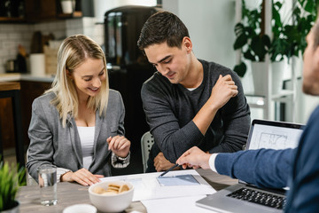 Young couple going through blueprints with their real estate agent.