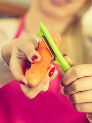 Woman peeling carrot vegetable