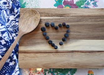 Obraz na płótnie Canvas blueberries on a board arranged as a heart 
