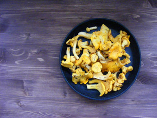 Top flat view of chanterelle mushroom on black cast iron plate