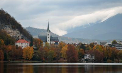 Fototapeta na wymiar Lake Bled Slovenia. Beautiful mountain lake with small Pilgrimage Church. Most famous Slovenian lake and island Bled with Pilgrimage Church of the Assumption of Maria and Bled Castle in background.