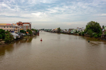 Fototapeta premium A landscape pictures of the shores of the mekong river in south vietnam near vinh long on a sunny summer day.