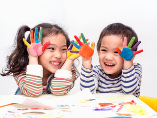 Funny two asian cute girl playing watercolor painting at paper and hands. Happy and fun activity for children. Learning and education of kid.