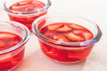 Strawberry Jelly with Sliced Strawberries in a Glass Bowls on White Background