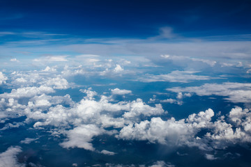 Plane window view with blue sky and clouds. Clouds and sky as seen through window of an aircraft. View of beautiful cloud and city from the airplane.