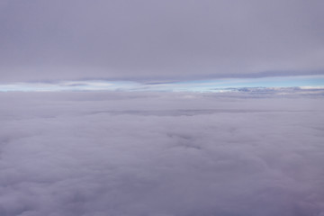 Obraz premium Plane window view with blue sky and clouds. Clouds and sky as seen through window of an aircraft. View of beautiful cloud, ocean and city from the airplane.