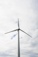 One wind turbine on overcast sky.