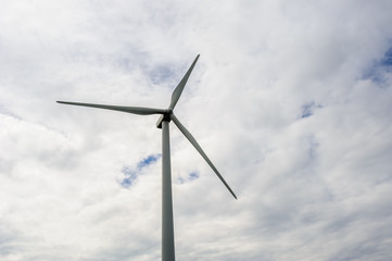 Fototapeta premium One wind turbine on overcast sky.