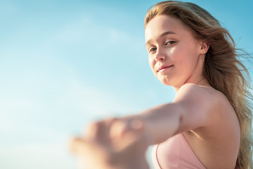 young slim beautiful woman in pink bikini on tropical beach. Portrait of happy young woman smiling at sea. Girl in swimwear enjoying and walking on beach.