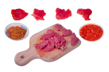 Obraz premium Appetizing red fresh veal, sliced into raw thin beef, chili and coconut fried or Kerisik isolated on white background
