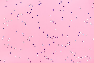 Holographic square silver confetti on pink pastel background.