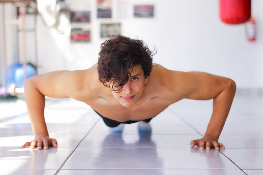 Retrato de Hombre entrenando en gimnasio de box pushup