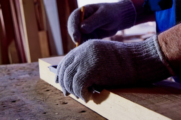 Carpenter works on woodworking machines in the carpentry workshop. A man works with a tree