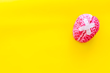 Mental health concept with patches on brain on yellow background top view mockup