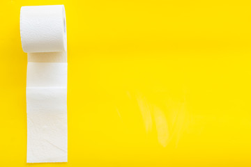 Toilet paper roll on yellow background top view copy space