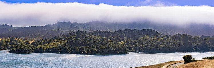 Upper Crystal Springs Reservoir,  part of the San Mateo Creek watershed and Santa Cruz mountains covered with clouds visible in the background; San Mateo, San Francisco bay area, California