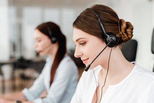 Professional young office worker with a headset  answering in a call center, woman talking with clients. Portrait of an attractive customer and technical support representative. Business concept