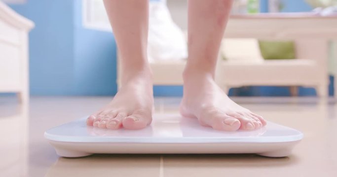 woman stand on weight scale