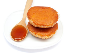 Honey is an ingredient in making various types of sweets in white plate isolated on white background.