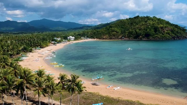 Aerial reveal shot of double beach bay. Nacpan beach, El Nido , Palawan, Philippines