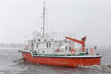 Test the motor boat on the Kama River in the late fall in snowfall