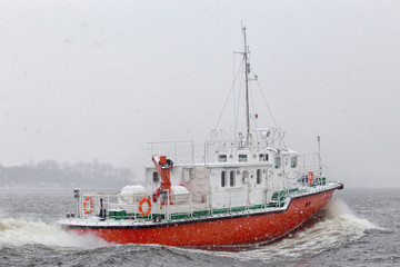 Fototapeta premium Test the motor boat on the Kama River in the late fall in snowfall