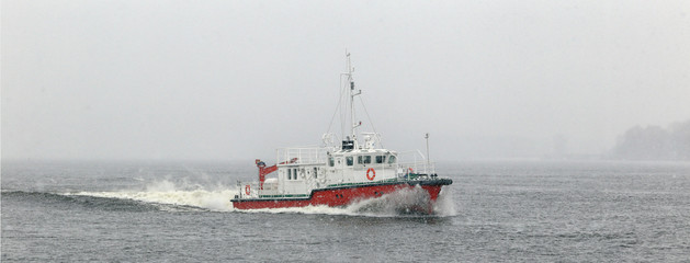 Test the motor boat on the Kama River in the late fall in snowfall