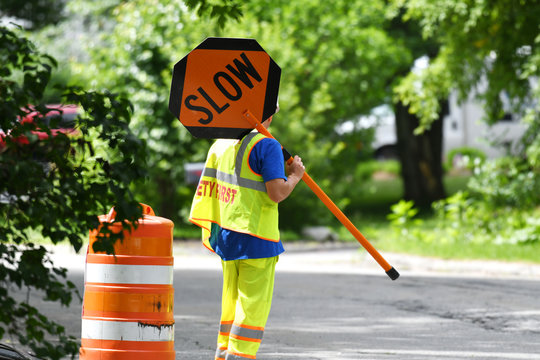 outdoor worker hold slow sign at road construction site