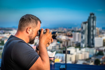 Male photographs on a digital camera panorama of the city of Pattaya, Thailand.